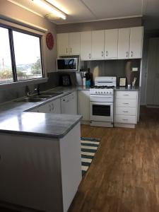坎贝尔港山居度假屋的厨房配有白色橱柜和炉灶烤箱。