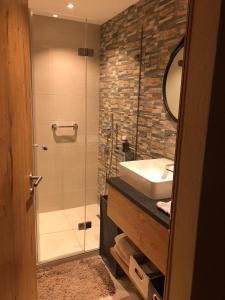 Laax-MurschetgLaax Flims Luxury Large apartment near Rock Resort的带淋浴、盥洗盆和镜子的浴室