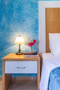 斯科派洛斯阿伊奥罗斯酒店的床头床头柜上的一张桌子和一盏灯