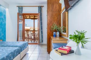 斯科派洛斯阿伊奥罗斯酒店的一间卧室配有一张床铺和一张桌子,并设有一个阳台