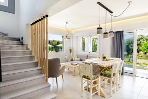 普拉基亚斯IRIDA Guesthouse by the Pool的用餐室以及带桌椅和楼梯的厨房。