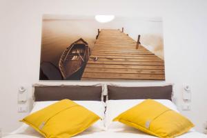 萨维勒特里Casa Felice的一张码头和一张带黄色枕头的床的照片
