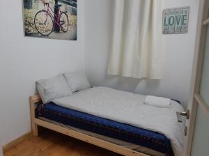 海法BE ME Hotels and Hostels HAIFA ART的墙上有自行车的一张小床
