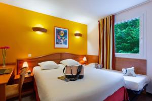 岩尼维利B&B HOTEL Amneville-les-Thermes的酒店客房设有两张床和窗户。
