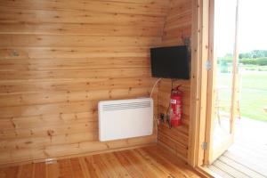 林肯Glamping at Spire View Meadow的客房设有木墙、电视和暖气。