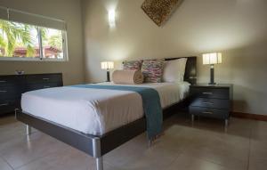棕榈滩斯梅拉达村海滨度假屋的一间卧室配有一张大床、两盏灯和一个窗户。