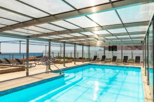波尔图博维斯塔酒店的一座带大型玻璃天花板的室内游泳池