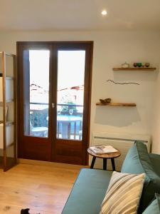 代米考迪亚Appartement cosy et chaleureux à Megève avec vue sur le Mont Blanc的带沙发和玻璃门的客厅