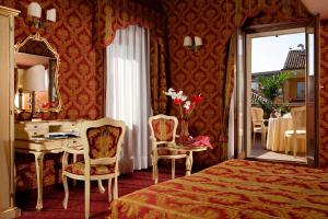 威尼斯高瑞兹酒店的一间卧室配有一张床、一张书桌和一面镜子