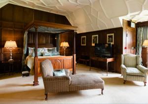 埃登布里奇赫弗堡豪华住宿加早餐酒店的一间卧室配有一张床、一张沙发和一把椅子