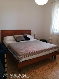 比萨Villa Galilei Rooms的一间卧室配有一张大床和木制床头板