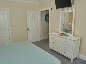 汉普顿大西洋微风套房酒店的一间卧室配有一张床、梳妆台和镜子