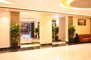 塔伊夫Borj Al Thahabiah ApartHotel的大堂配有沙发和盆栽植物
