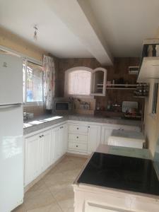 埃尔哈豪拉Miramar的厨房配有白色橱柜和黑色台面