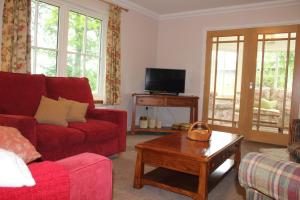 亨特利Roualeyn的客厅配有红色沙发和茶几