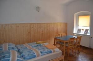 Dolní BeřkoviceUbytování U Tajčů的一间卧室配有一张床、一张桌子和一个窗户。