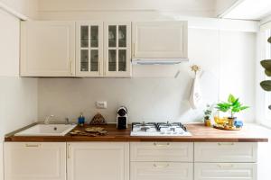 布加勒斯特Emerald Oasis的厨房配有白色橱柜和炉灶烤箱。