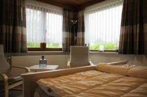 于克里茨Bungalow am Forsthaus Stagnieß的一间卧室配有一张床、两把椅子和窗户