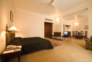 SikaHotel Express Residency-Jamnagar的一间卧室设有一张床和一间客厅。