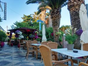 利瓦纳太Hotel Akti的一个带桌椅的庭院,棕榈树