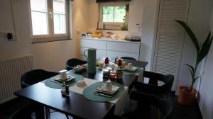 艾斯登Huize Mesch的一间带桌椅的用餐室和一间厨房