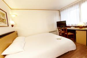 穆瓦朗钟楼格勒诺布尔北莫兰沃雷普酒店的一间酒店客房,配有一张白色的床和一张书桌