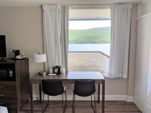 乔治湖Lakefront Terrace Resort的窗户前的餐桌和椅子