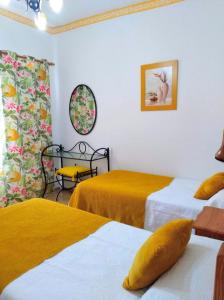 丰卡连特德拉帕尔马Pensión Los Volcanes的客房 - 带两张带黄床单的床