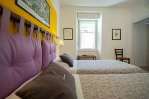特伦托莫瓦西亚住宿加早餐旅馆的一间卧室设有两张紫色和黄色墙壁的床。