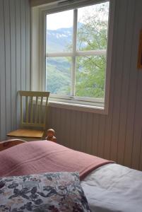 埃兹达尔海斯特豪格加尔酒店的卧室设有窗户、一张床和椅子