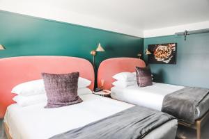 博兹曼RSVP Hotel的配有两张床铺的蓝色和绿色墙壁客房