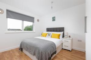 恩菲尔德Skyvillion - COZY APARTMENTS in Enfield Town With Free Parking & Wifi的白色的卧室设有床和窗户