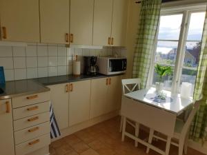 格兰纳Bergsgatan 64的厨房配有白色橱柜、桌子和微波炉