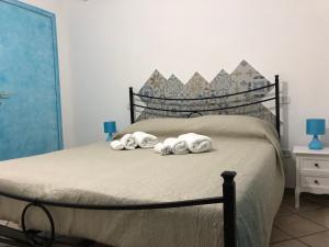 DecimomannuLe terre cotte的一间卧室配有带毛巾的床