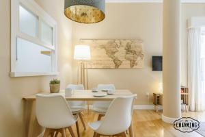 马德里Charming Fuencarral III - Estancias Temporales的一间带桌子和白色椅子的用餐室