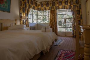 德尔斯特鲁姆Valley Of The Rainbow Estate的卧室设有一张白色大床和一扇窗户。
