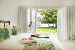 马洛洛莱莱罗马尼岛度假酒店 - 仅限成人入住的一间卧室配有一张带鲜花的大床