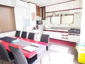 那霸壶屋2号度假屋的厨房配有红色的餐桌和椅子