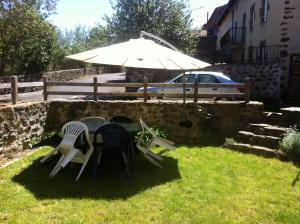 Chaspuzacmaison Mouilhade的院子里的桌椅和雨伞