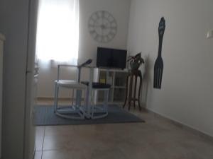 波尔图Made in You - Oporto Guesthouse的客厅配有桌椅和时钟