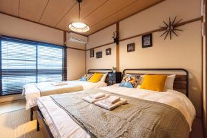 大阪Chachamaru Osaka Castle Park的一间卧室配有两张带毛巾的床