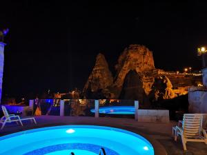 乌奇希萨尔赫尔墨斯窑洞酒店的享有度假村游泳池的夜景