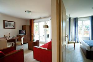 曼德琉-拉纳普勒Goélia Mandelieu Riviera Resort的酒店客房带一张床铺、一张书桌和一间卧室
