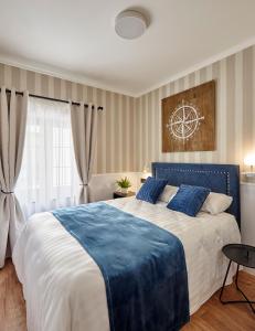 罗列特海岸"Breeze" Aparthotel by Parrot`s House的一间卧室配有一张带蓝色毯子的大床