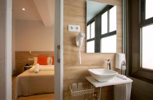 巴塞罗那三斯旅馆的一间带水槽、床和镜子的浴室