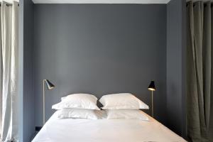 巴黎德鲁奥豪华公寓的一间卧室拥有蓝色的墙壁,配有一张带白色枕头的床。
