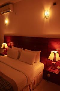 科伦坡独特大厦豪华精品套房酒店的一间卧室配有一张大床和两盏灯