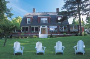 杰克逊杰克逊酒店的坐在房子前面的草上,有三把椅子