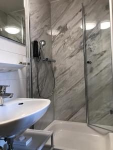 盖林根赫斯臣酒店的带淋浴和盥洗盆的浴室