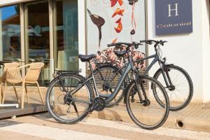 科洛尼亚圣霍尔迪Hotel Colonial的两辆自行车停在商店外面